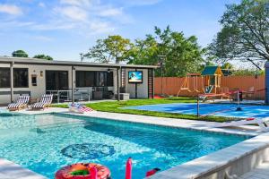 una piscina con parque infantil y una casa en Luxury Getaway with Retreat Heated pool and Jacuzzi L31, en Miami