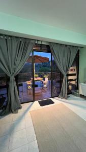 una sala de estar con cortinas y vistas a un patio. en The Hillview inn Meranti Park Suites, en Bentong