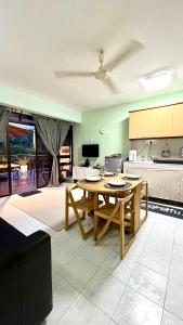 Una sala de estar con una mesa y una cocina. en The Hillview inn Meranti Park Suites, en Bentong