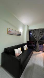 Sofá negro en una sala de estar con ventana en The Hillview inn Meranti Park Suites, en Bentong 31 fotos más
