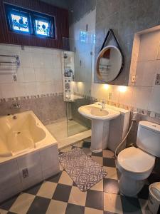 a bathroom with a sink and a tub and a toilet at Hening Pool Residence in Purwokerto