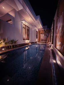 a swimming pool in a house at night at Hening Pool Residence in Purwokerto
