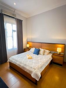 a bedroom with a large bed with two lamps on it at Hening Pool Residence in Purwokerto +27 photos