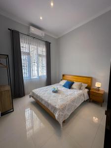 um quarto com uma cama grande e uma janela em Hening Pool Residence em Purwokerto