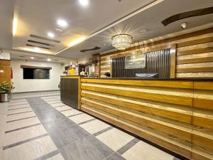 um átrio de restaurante com painéis de madeira e um bar em The Grand Hotel Multan em Multan