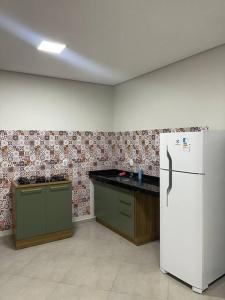 eine Küche mit einem weißen Kühlschrank im Zimmer in der Unterkunft Apartamento com vista para palco festival in Chapada dos Guimarães