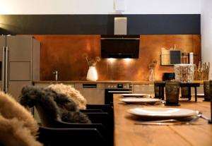 una cucina con tavolo lungo, sedie e bancone di Exklusives Stadthaus-Apartment am Staatstheather a Cottbus
