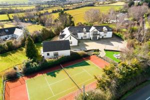 una vista aérea de una casa con pista de tenis en Winton Grove – for outdoor and tennis enthusiasts, en Kilmacanoge