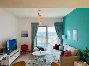 Full Canal View Apartment at Yas Island- Brand New في أبوظبي: غرفة معيشة مع أريكة وتلفزيون