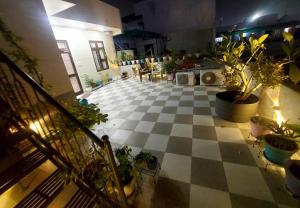 um quarto com um piso xadrez com vasos de plantas em Aradhyas Stay em Jaipur