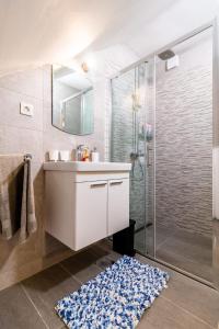 a bathroom with a sink and a shower and a rug at Studio apartman Mirela Kaštel Štafilić in Kaštela