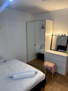 ein Schlafzimmer mit einem großen Spiegel und einem Bett in der Unterkunft Cozie 1 BR apartment in Manchester