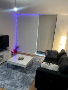ein Wohnzimmer mit einem Sofa und einem Tisch in der Unterkunft Cozie 1 BR apartment in Manchester
