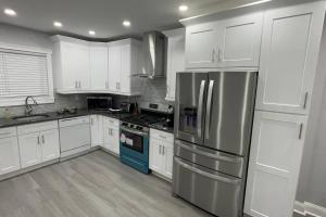 a kitchen with white cabinets and stainless steel appliances at The Hidden Gem in Philadelphia