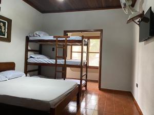 Zimmer mit 2 Etagenbetten und einem Fenster in der Unterkunft LARA'S HOUSE in São Sebastião