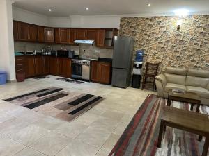 a large kitchen with a couch and a stove at Masaki - 2 Bedroom Apartment in Dar es Salaam