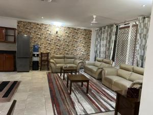 a living room with couches and tables and a stone wall at Masaki - 2 Bedroom Apartment in Dar es Salaam