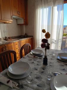 a dining room table with plates and glasses on it at Apartamentos La Sierra in Villalba de la Sierra
