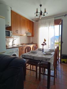 eine Küche mit einem Tisch und Stühlen sowie ein Esszimmer in der Unterkunft Apartamentos La Sierra in Villalba de la Sierra