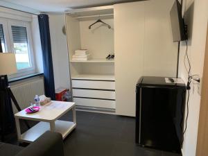 a living room with a small table and a refrigerator at Günstige Zimmer-Unterkunft Zimmer mit Gemeinschaftsbad in Lörrach