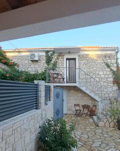 une maison en pierre avec un escalier et une terrasse dans l'établissement Apartments Tomina, à Donje Selo na Šolti