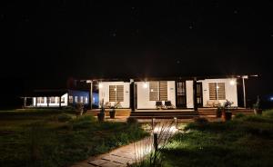 a house lit up at night with lights at Camp TigerLily - Dudhwa in Bhīra