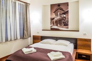 1 dormitorio con 1 cama con 2 toallas en Vila Wendy, en Sinaia
