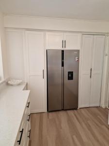 a stainless steel refrigerator in a room with white cabinets at 2 Bed, parking, gated, modern in Saint Augustine