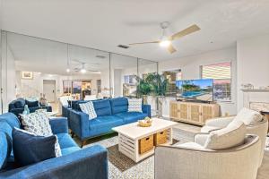 a living room with blue couches and a tv at Bayside Escape - 1345 in Siesta Key