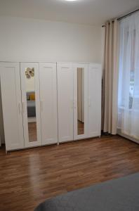 um grupo de armários brancos com espelhos num quarto em Apartmán u Fontány em Poděbrady