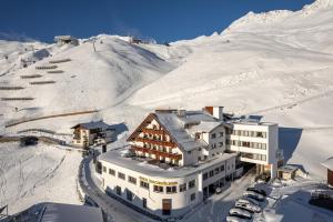 ein Gebäude im Schnee neben einem Berg in der Unterkunft Hotel Hochsölden in Sölden