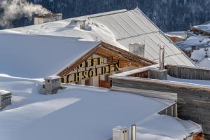 ein Schild auf dem Dach eines schneebedeckten Gebäudes in der Unterkunft Hotel Hochsölden in Sölden