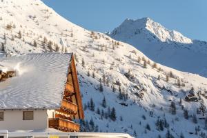 a snow covered mountain next to a cabin at Hotel Hochsölden in Sölden