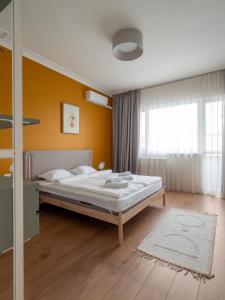 een slaapkamer met een bed en een gele muur bij Central Apartment Parking Two Bedrooms Sky Terrace in Sofia