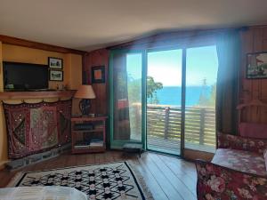una camera da letto con balcone affacciato sull'oceano di Casa Isla Negra con hermosa vista al mar a Isla Negra
