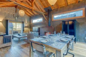 a dining room with a large wooden table with chairs at A 2 min du télécabine Chalet de charme 4 étoiles in Les Houches