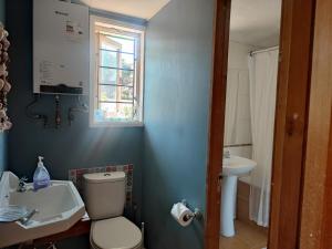 a bathroom with a toilet and a sink and a window at Casa Isla Negra con hermosa vista al mar in Isla Negra +19 photos