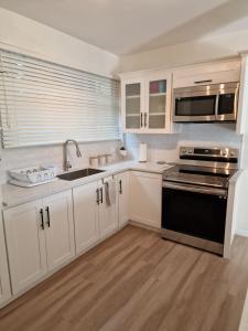 a kitchen with white cabinets and a black stove top oven at 2 Bed, parking, gated, modern in Saint Augustine