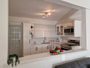 una cocina con armarios blancos y un bol de fruta en 2 Bed, parking, gated, modern, en Saint Augustine
