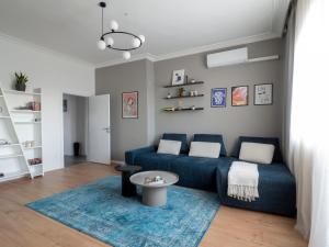 een woonkamer met een blauwe bank en een tafel bij Central Apartment Parking Two Bedrooms Sky Terrace in Sofia