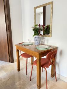 卡薩布蘭卡的住宿－Appartement Luxe - Casablanca，一张带两把椅子和镜子的木桌
