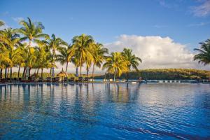 une grande piscine avec des palmiers et de l'eau dans l'établissement Shandrani Beachcomber Resort & Spa, à Blue Bay
