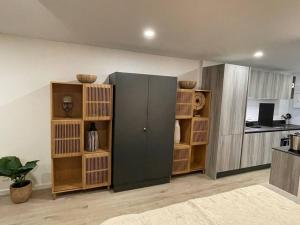 Habitación con estanterías de madera y nevera grande. en Studio Tamarin, en Saint Martin