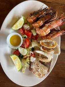 a plate of food with shrimp and vegetables and dipping sauce at Pangani Cliffs Lodge in Pangani