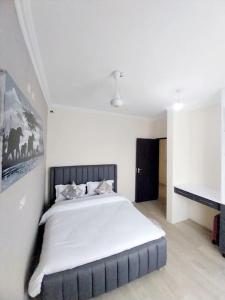 um quarto com uma cama grande e lençóis brancos em Eleganza Suites em Kilifi