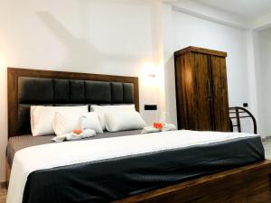 a bedroom with a large bed with a wooden headboard at Weligama Bay House in Weligama