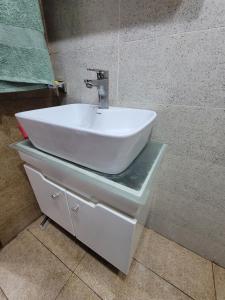 a white sink on a counter in a bathroom at Ultra muse Studio Apartment in Lahore