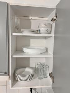 a white pantry with plates and glasses and dishes at Vaasa homestay in Vaasa