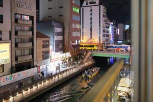 大阪道頓堀民泊31＆mini浮世絵美術館、道頓堀心斎橋真ん中、家族旅行、family trip Osaka的夜空在城市的河流中