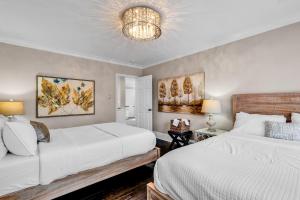 a bedroom with two beds and a chandelier at Bright and Modern Close to Everything in Charlotte